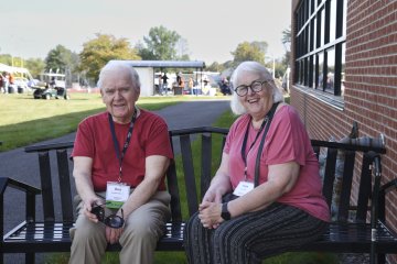 Ron ’70 and Fran Pytko sit on a bench on a sunny day during Homecoming 2025.
